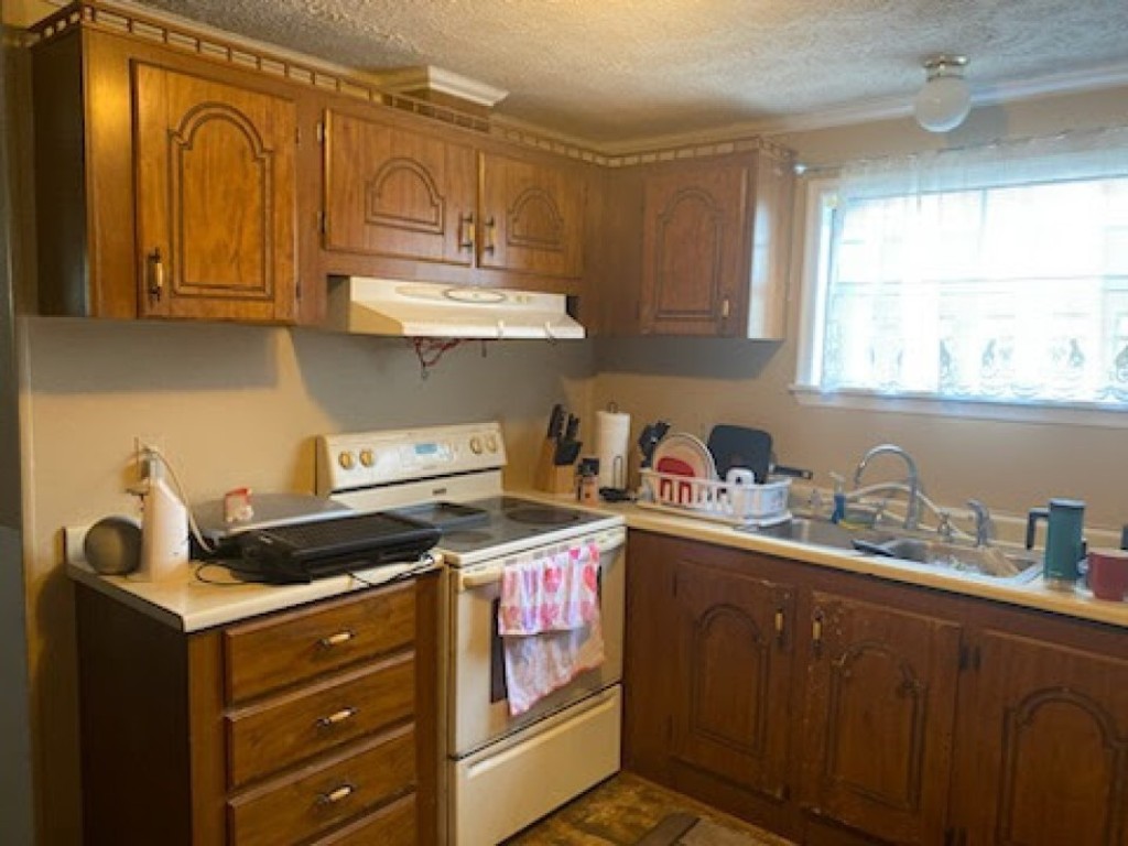 97119 Diamond Street Yulee, FL 32097 - Photo 3 of 6 a kitchen with stainless steel appliances granite countertop a stove a sink and cabinets