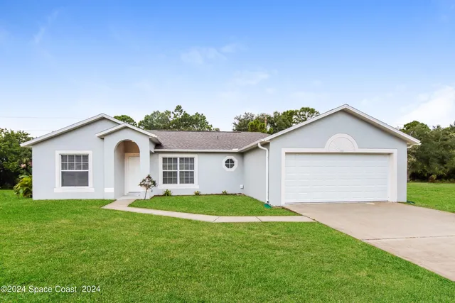 a front view of house with yard and garage
