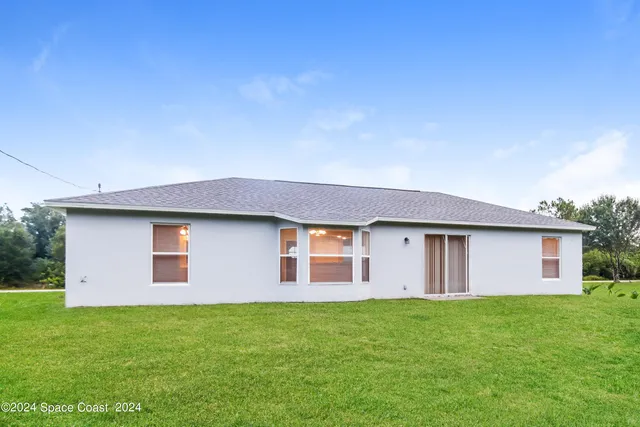a backyard of a house with a garden and plants