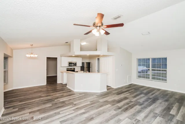 a view of a kitchen with wooden floor and a ceiling fan