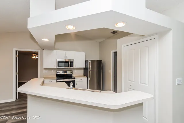 a kitchen with kitchen island a refrigerator sink and stove