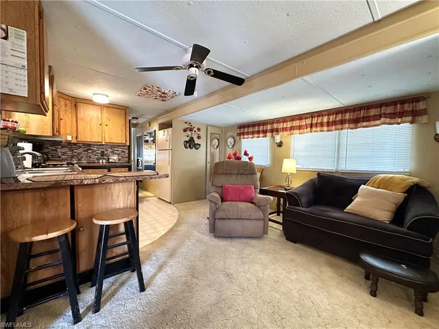 a living room with furniture and kitchen view
