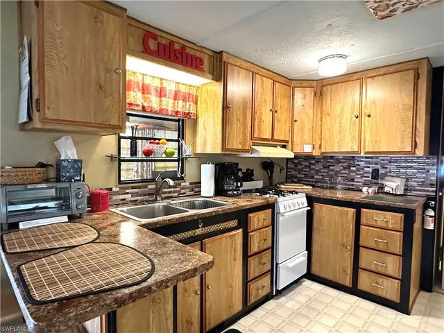 a kitchen with stainless steel appliances granite countertop a sink stove and cabinets