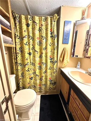 a bathroom with a granite countertop sink toilet and a mirror