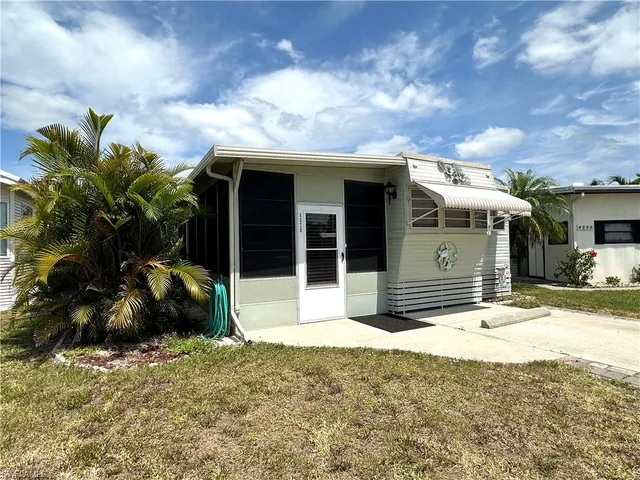a view of a house with a patio and a yard