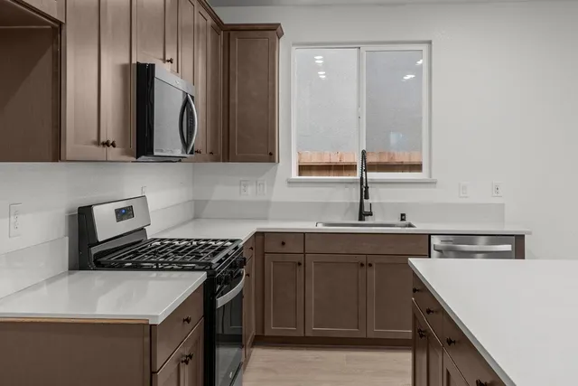 a kitchen that has a sink and a stove in it