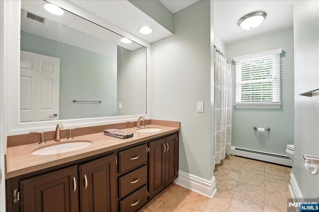 856 Stonewall Court Franklin Lakes, NJ 07417 - Photo 17 of 26 a bathroom with a granite countertop sink and a mirror