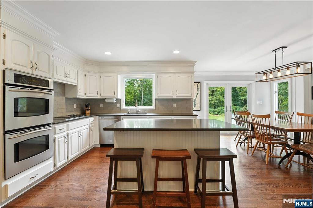 856 Stonewall Court Franklin Lakes, NJ 07417 - Photo 7 of 26 a kitchen with stainless steel appliances granite countertop a stove top oven a sink a dining table and chairs