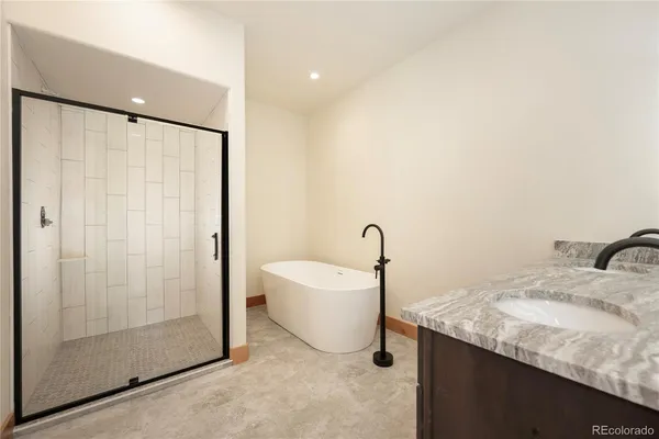 a bathroom with a granite countertop sink a mirror and a bathtub