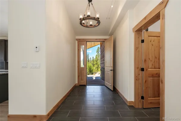 a view of a hallway with wooden floor and stairs