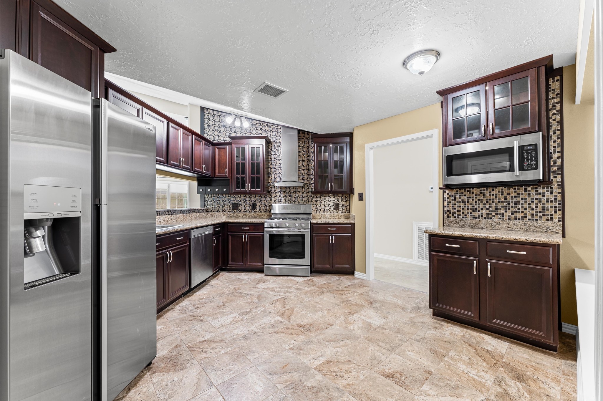 a kitchen with stainless steel appliances granite countertop a refrigerator and a sink