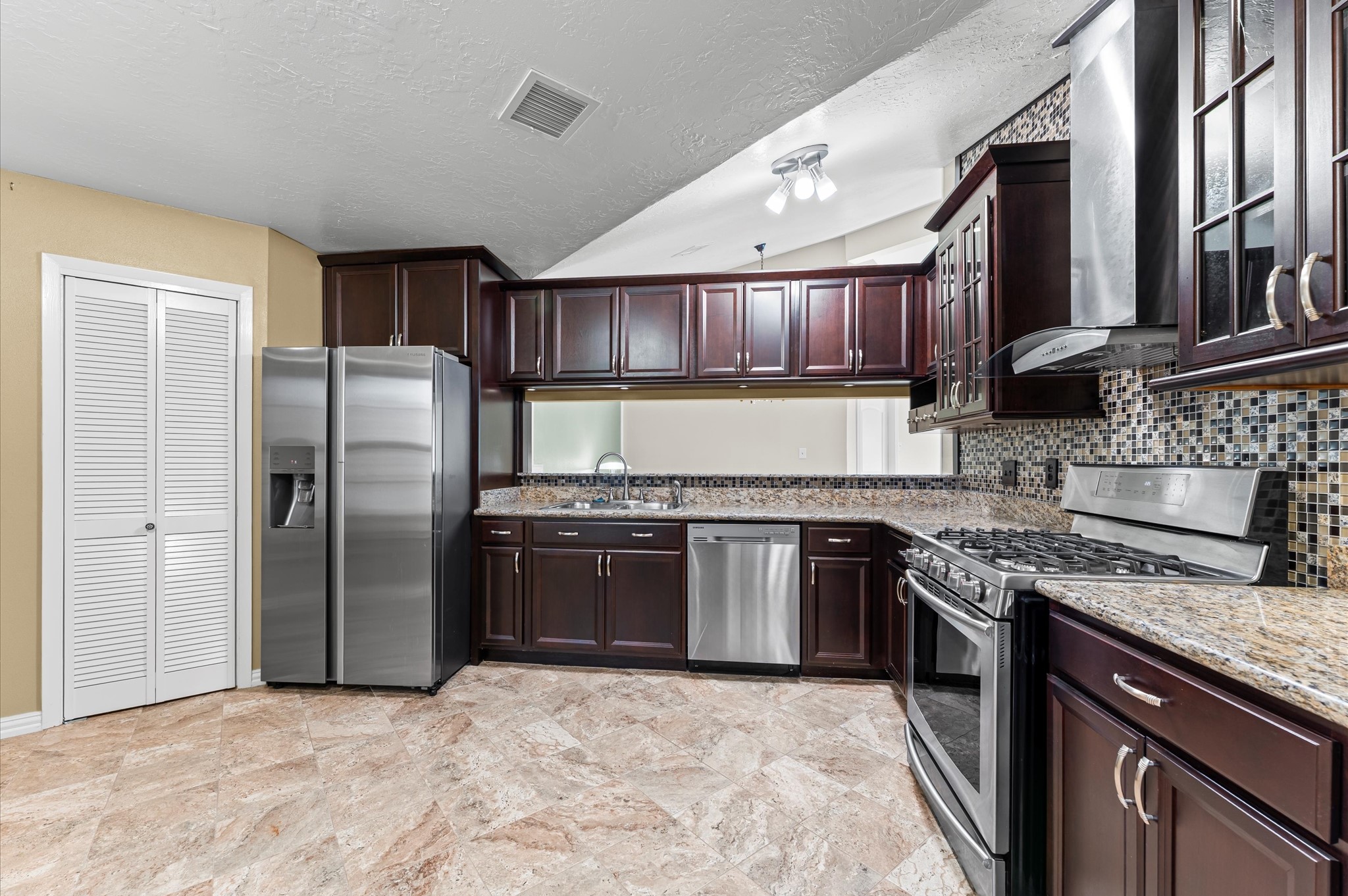 17015 Sky Blue Place Houston, TX 77095 - Photo 2 of 25 a kitchen with stainless steel appliances granite countertop a stove top oven a refrigerator and a sink