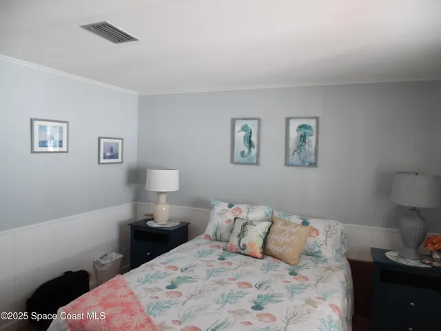 a bedroom with a bed and a lamp on dresser