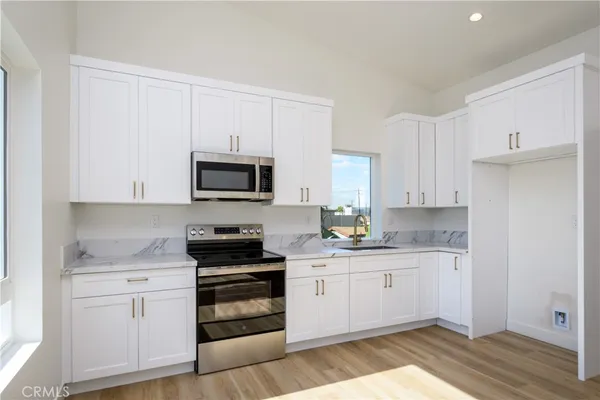 a kitchen with white cabinets and appliances