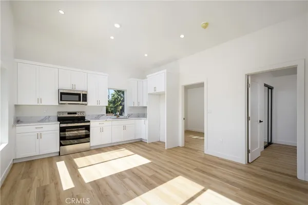 a kitchen with granite countertop a refrigerator and a stove top oven