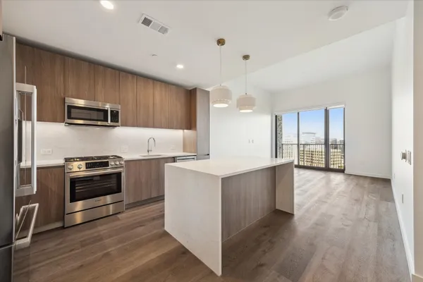 a kitchen with granite countertop a stove top oven and refrigerator