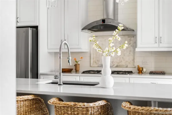 a kitchen with stainless steel appliances kitchen island granite countertop a table chairs and a refrigerator