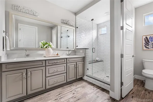 a bathroom with a granite countertop sink a mirror and shower