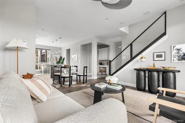 a living room with furniture a rug and a dining table