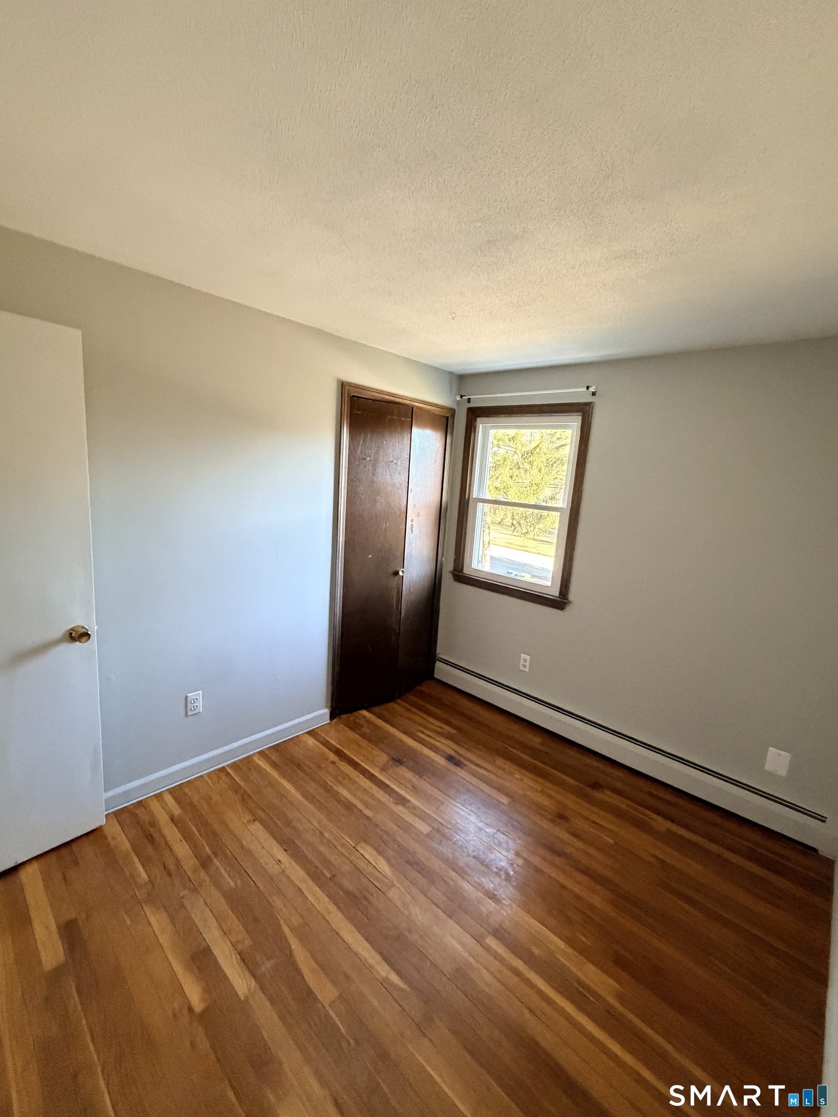 195 Wall Street Hebron, CT 06248 - Photo 20 of 23 a view of an empty room with window and wooden floor