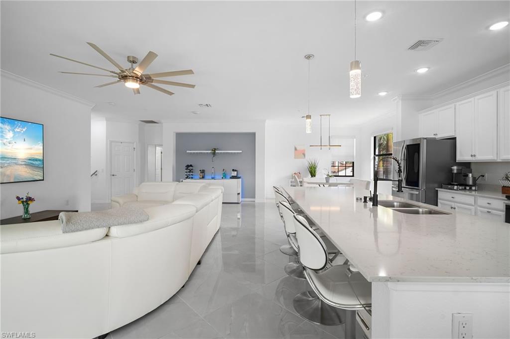 11879 Arboretum Run Drive, Unit 201 Fort Myers, FL 33913 - Photo 17 of 37 Living room featuring crown molding, a ceiling fan, recessed lighting, and light marble finish floors