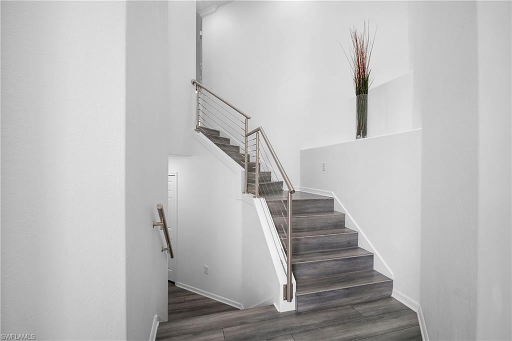 11879 Arboretum Run Drive, Unit 201 Fort Myers, FL 33913 - Photo 2 of 37 Staircase with wood finished floors and baseboards