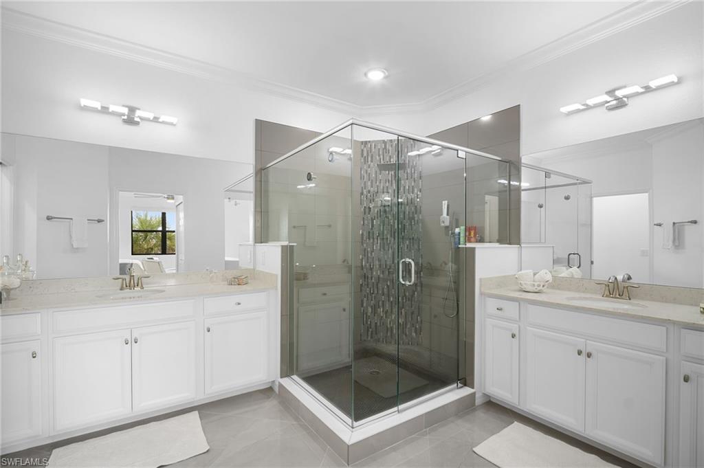11879 Arboretum Run Drive, Unit 201 Fort Myers, FL 33913 - Photo 27 of 37 Full bath with ornamental molding, two vanities, and a shower stall