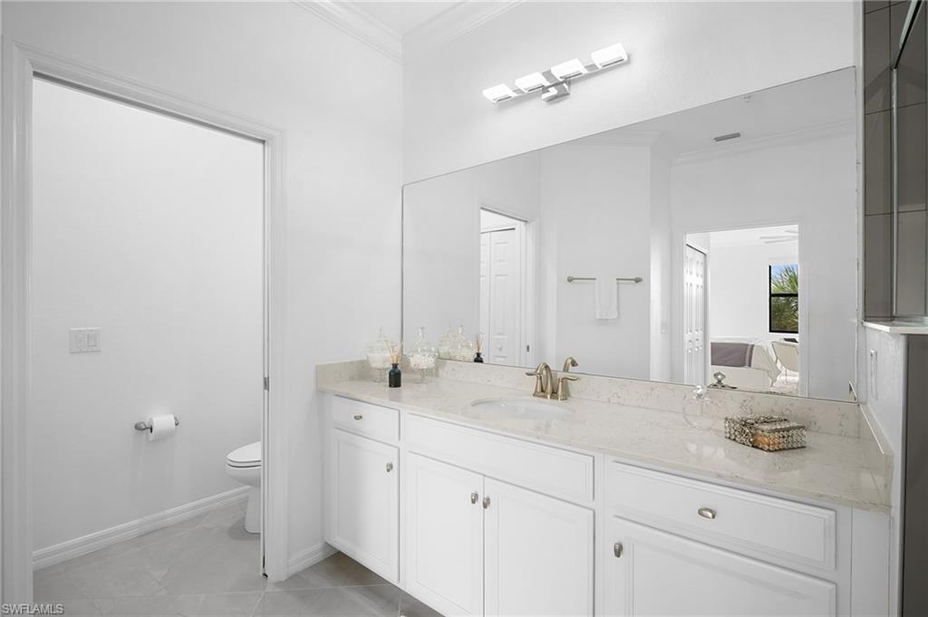 11879 Arboretum Run Drive, Unit 201 Fort Myers, FL 33913 - Photo 28 of 37 Ensuite bathroom with ornamental molding, vanity, and light tile patterned floors
