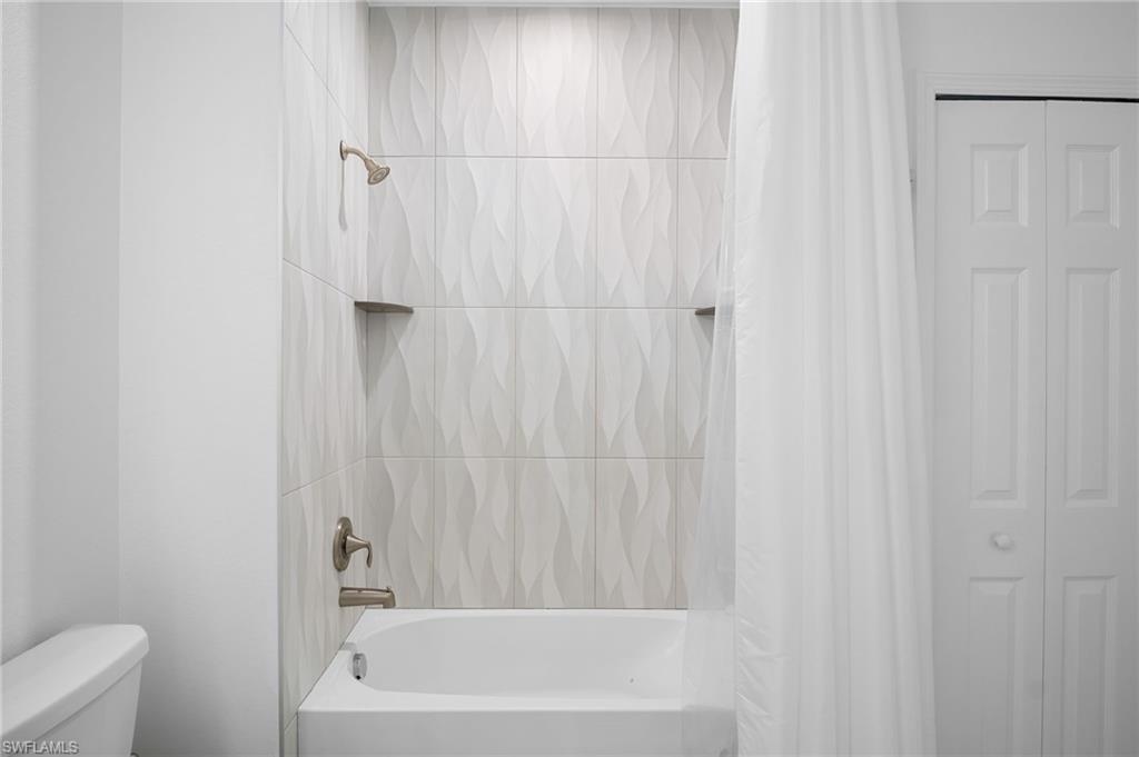 11879 Arboretum Run Drive, Unit 201 Fort Myers, FL 33913 - Photo 32 of 37 Bathroom with shower / bath combo and a closet