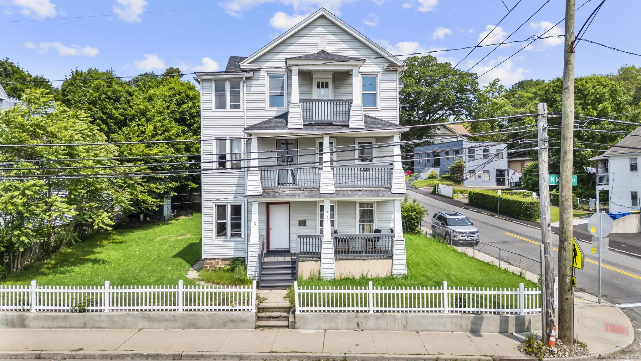 a view of a brick house with a yard and plants