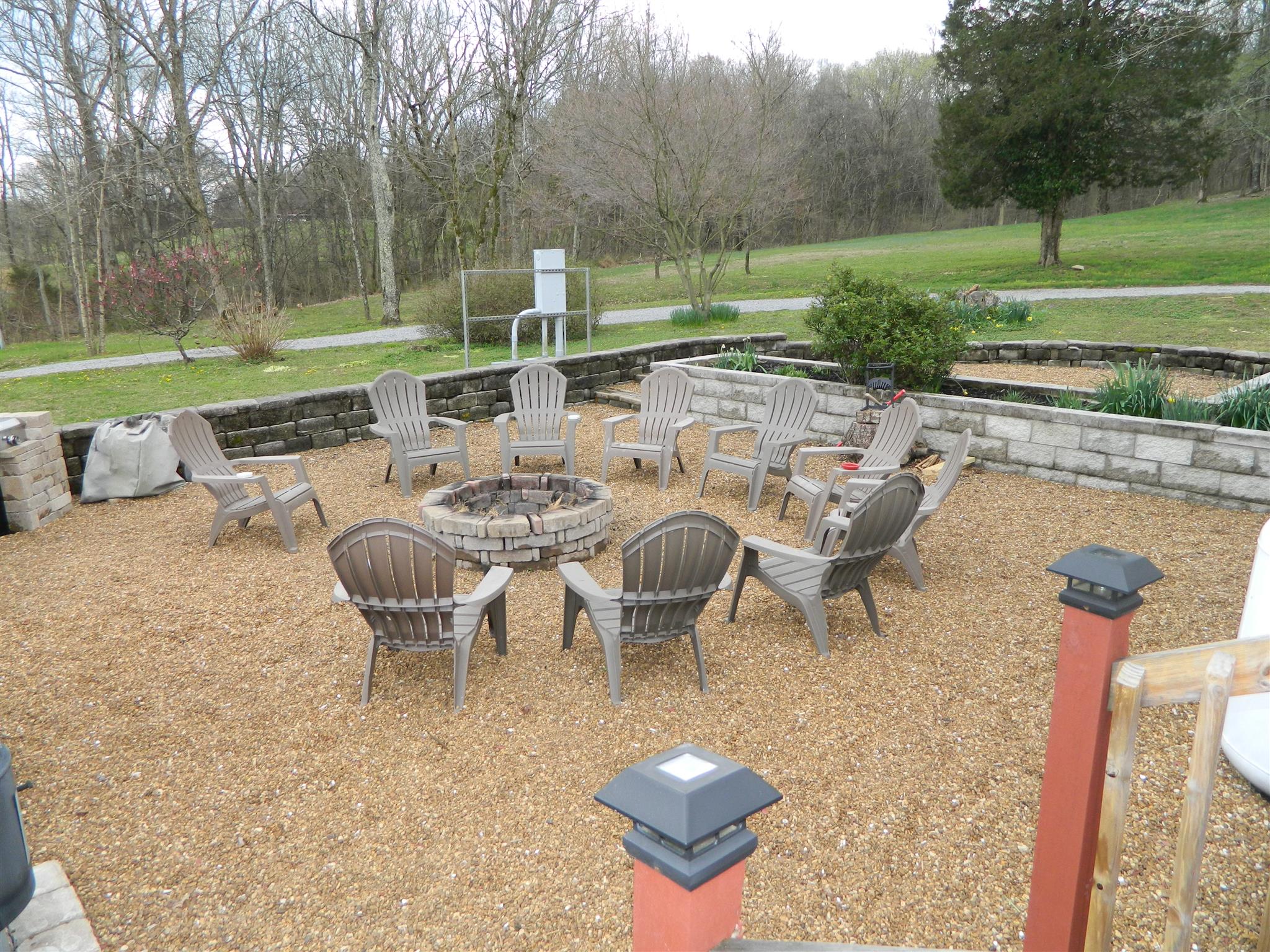 491 Pee Dee Branch Road Cottontown, TN 37048 - Photo 12 of 30 a view of a backyard with table and chairs potted plants and a palm tree