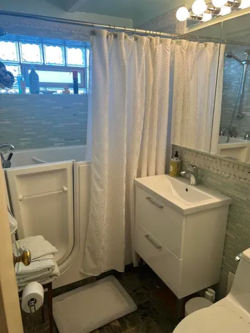 a bathroom with a sink a toilet and shower