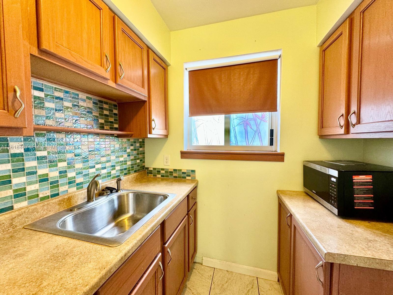 200 76th Street, Unit 52 Miami Beach, FL 33141 - Photo 12 of 16 a kitchen that has a sink and a stove