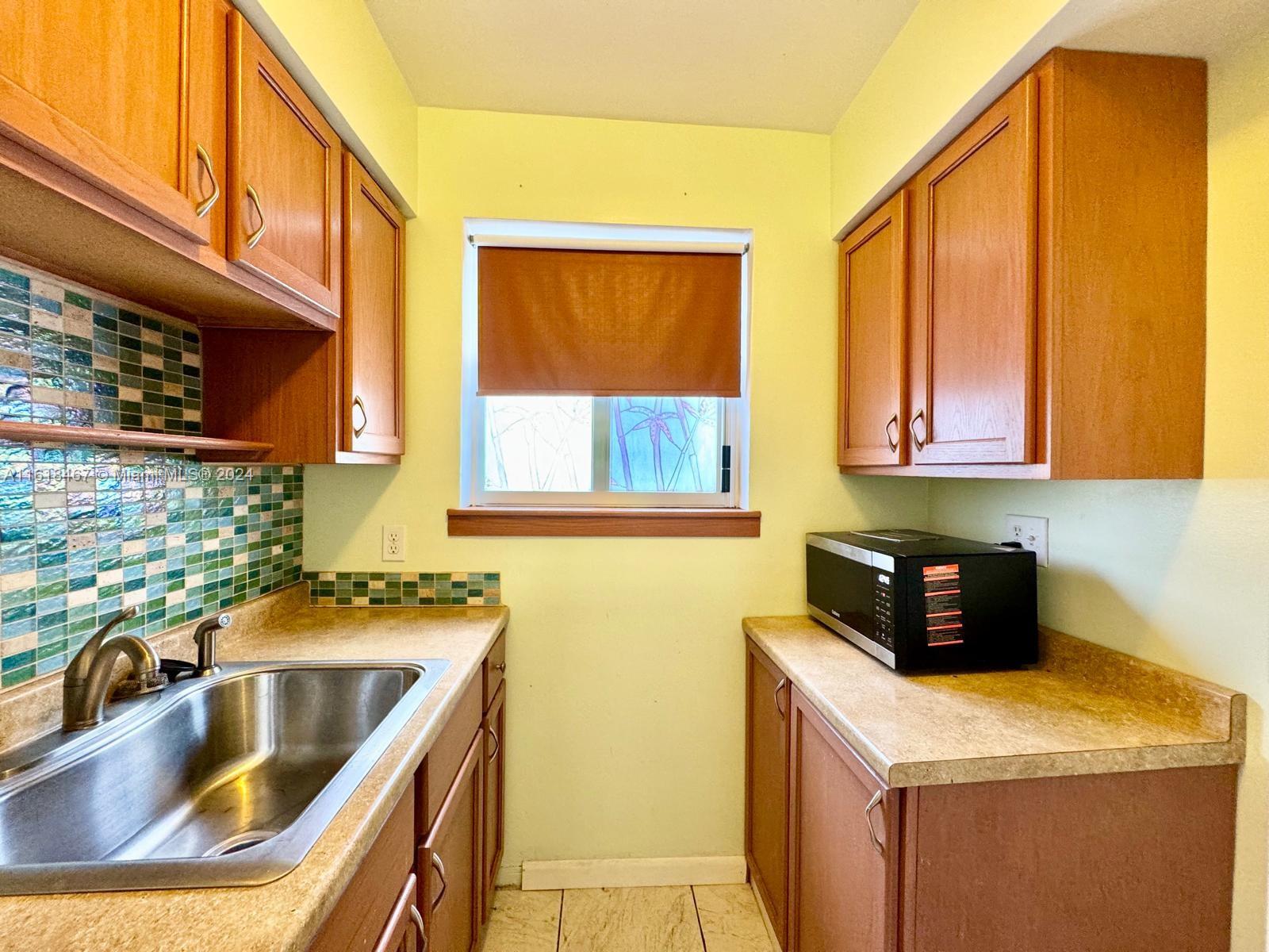 200 76th Street, Unit 52 Miami Beach, FL 33141 - Photo 13 of 16 a kitchen that has a sink and a stove in it