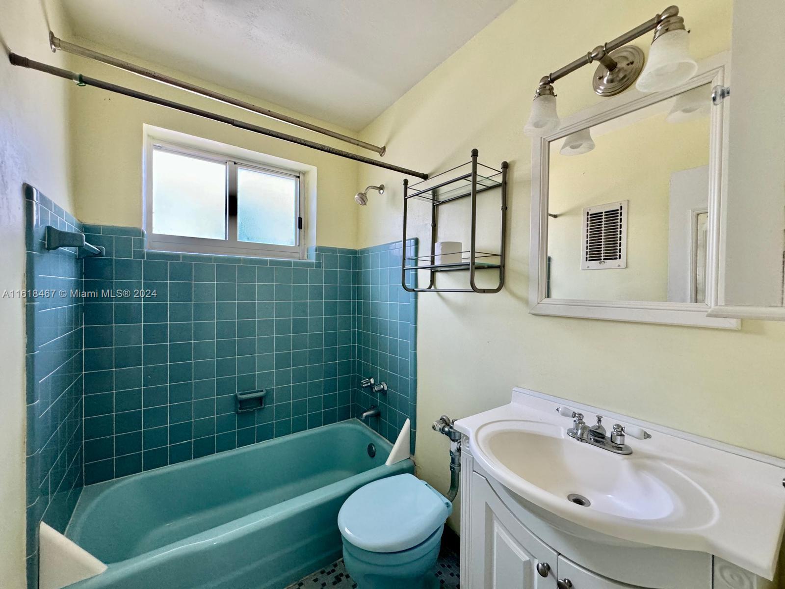 200 76th Street, Unit 52 Miami Beach, FL 33141 - Photo 15 of 16 a bathroom with a sink a toilet a mirror a bathtub and shower