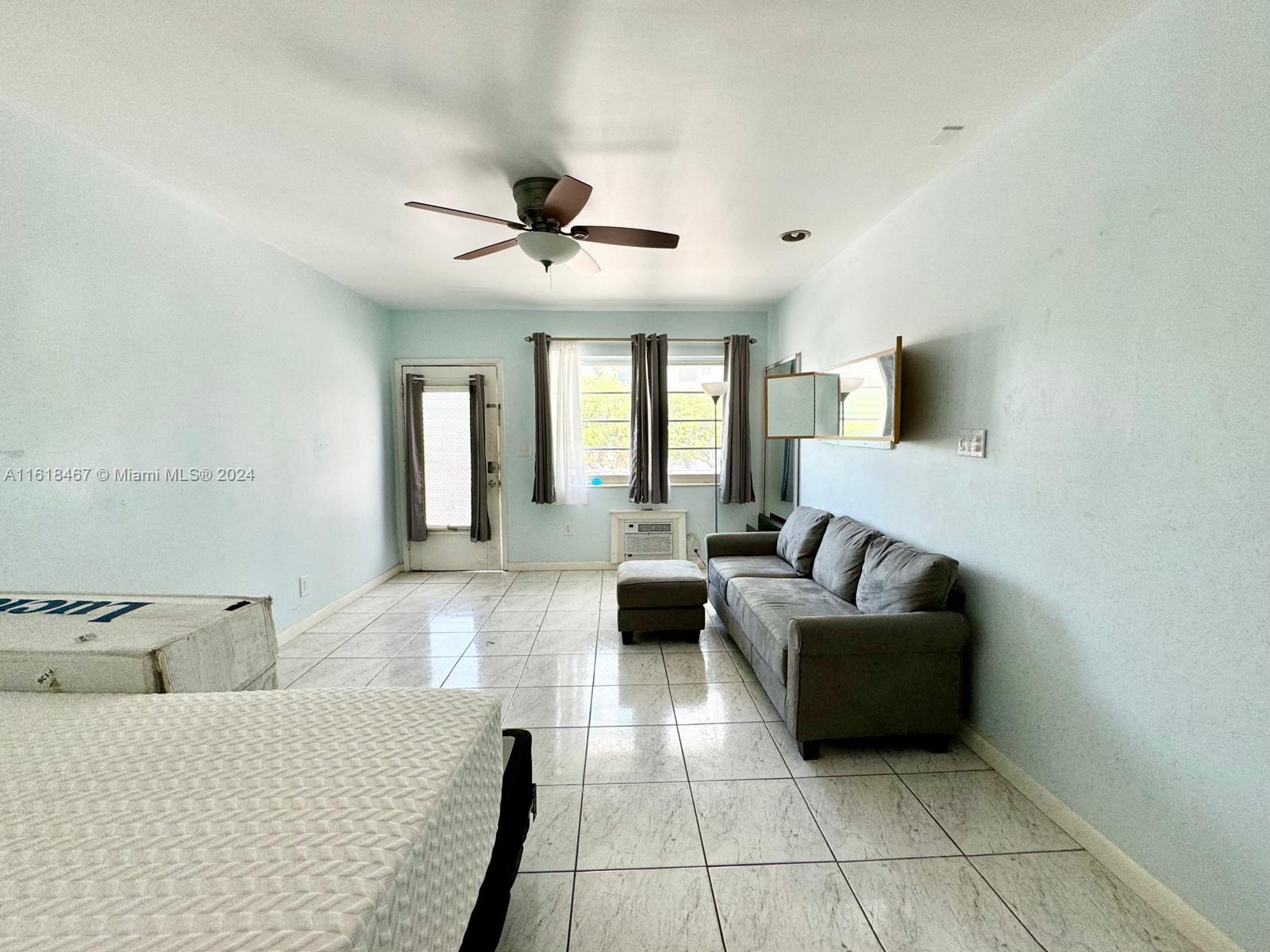 200 76th Street, Unit 52 Miami Beach, FL 33141 - Photo 8 of 16 a living room with furniture and a flat screen tv