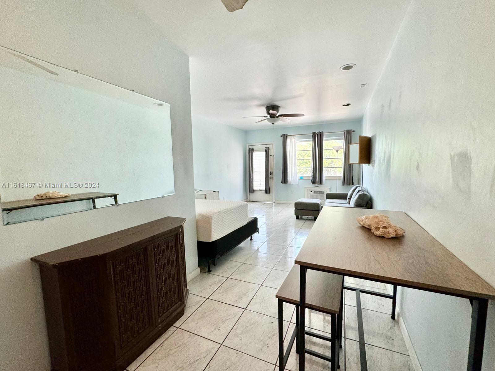 200 76th Street, Unit 52 Miami Beach, FL 33141 - Photo 9 of 16 a living room with furniture and a table