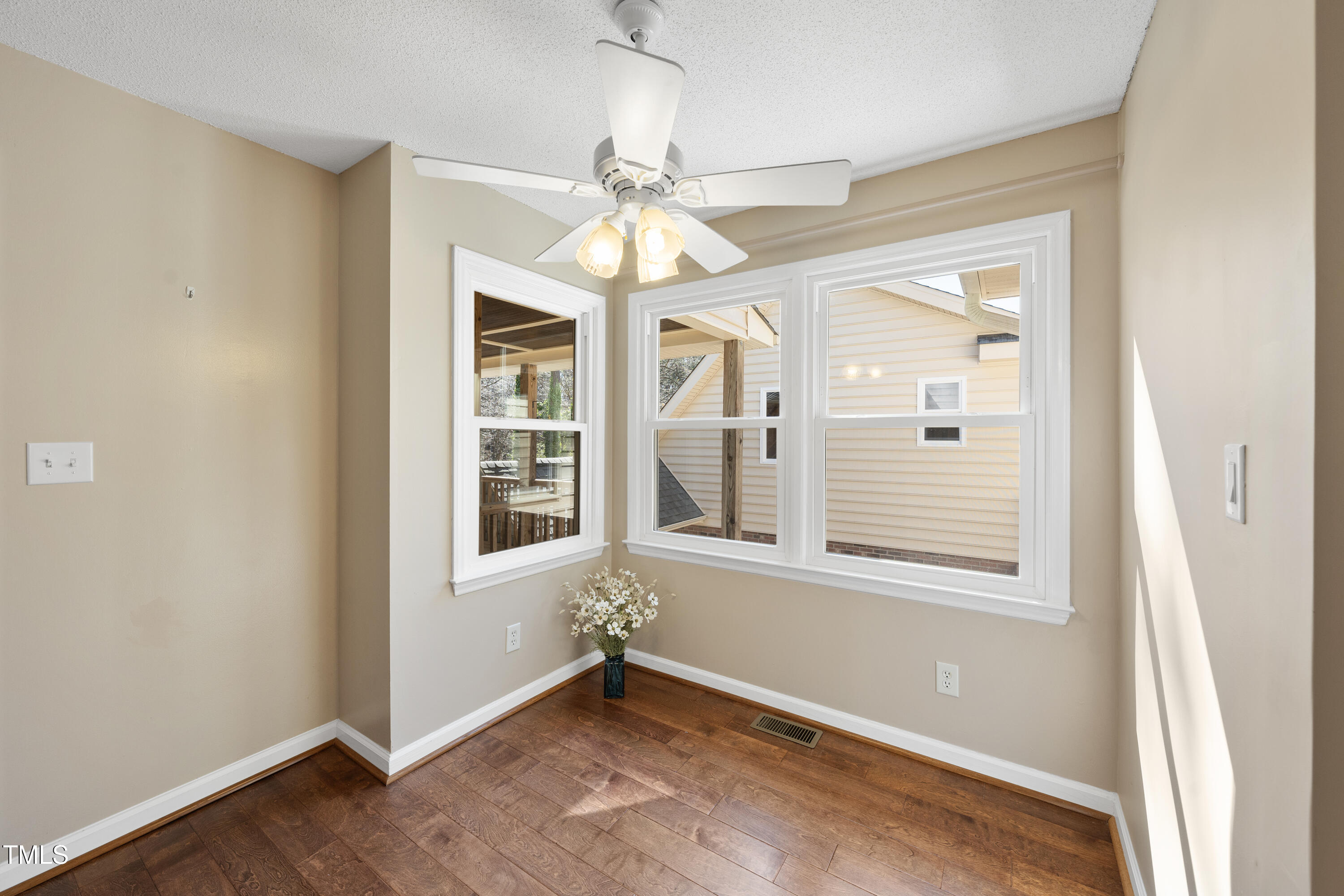 6301 King Lawrence Road Raleigh, NC 27607 - Photo 21 of 79 an empty room with wooden floor chandelier and windows