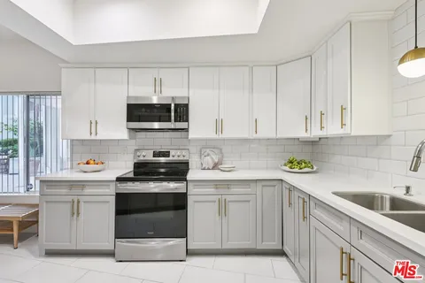 a kitchen with white cabinets and stainless steel appliances