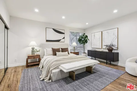 a bedroom with a bed and wooden floor