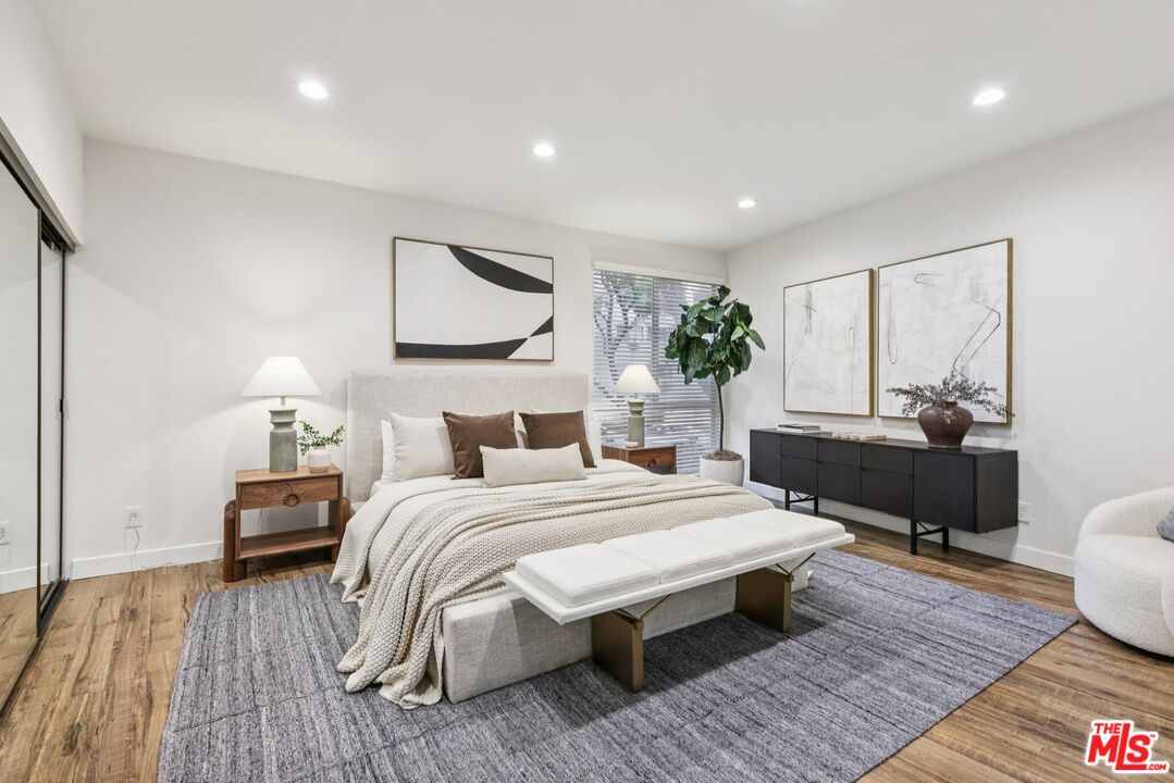 4242 Stansbury Avenue, Unit 104 Sherman Oaks, CA 91423 - Photo 21 of 38 a bedroom with a bed and wooden floor