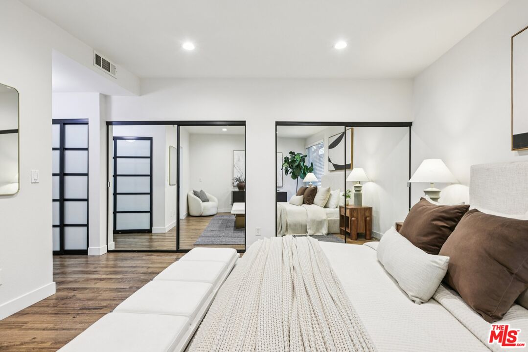 4242 Stansbury Avenue, Unit 104 Sherman Oaks, CA 91423 - Photo 22 of 38 a bedroom with a large bed and wooden floor