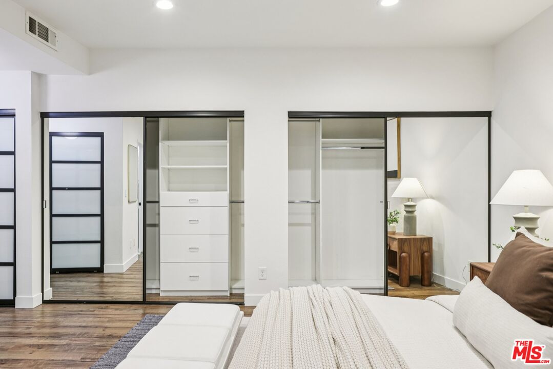 4242 Stansbury Avenue, Unit 104 Sherman Oaks, CA 91423 - Photo 23 of 38 a bedroom with a bed and a lamp on closet