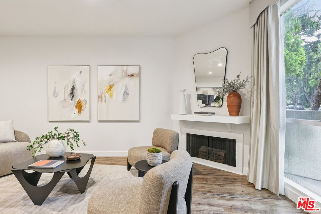 4242 Stansbury Avenue, Unit 104 Sherman Oaks, CA 91423 - Photo 8 of 38 a living room with furniture and a fireplace