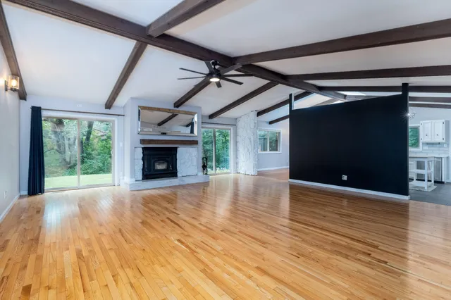 a view of empty room with wooden floor and fireplace