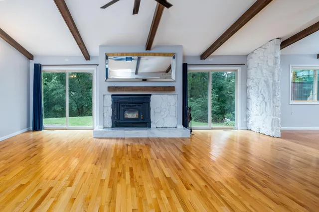 a view of empty room with wooden floor and fireplace