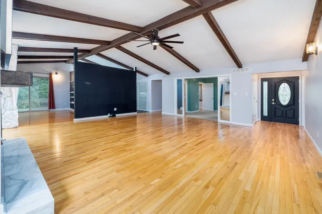 a view of an empty room with wooden floor
