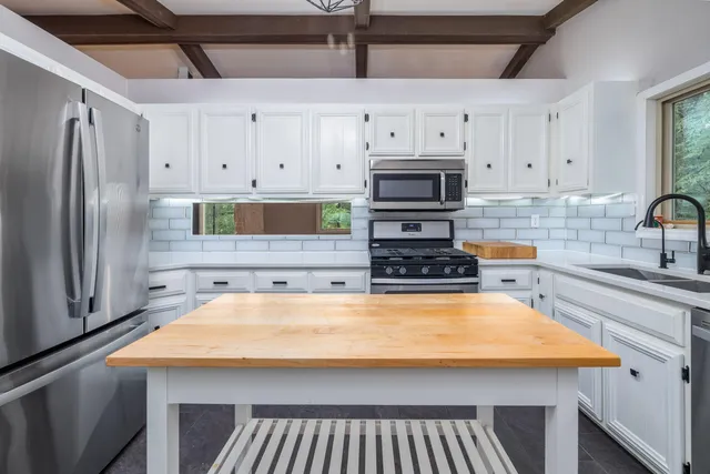 a kitchen with stainless steel appliances a stove a sink and a refrigerator