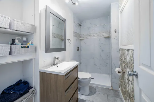 a bathroom with a sink a toilet and shower