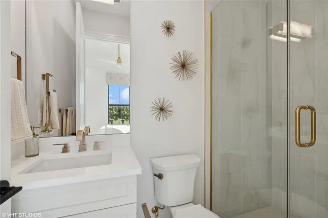 a view of a white house with a flower garden and a car parked